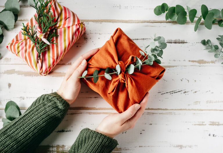 Wrapping a gift in eco-friendly reusable fabric package